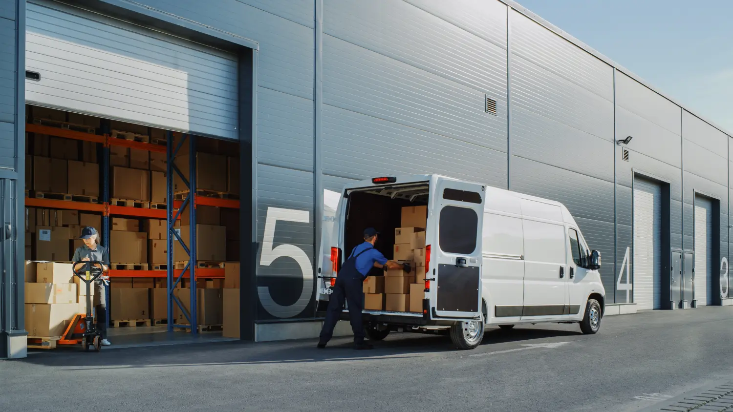 Außerhalb des Logistik-Einzelhandelslagers mit weiblicher Managerin, die einen Tablet-Computer nutzt, Arbeiter, der Lieferwagen mit Kartons belädt